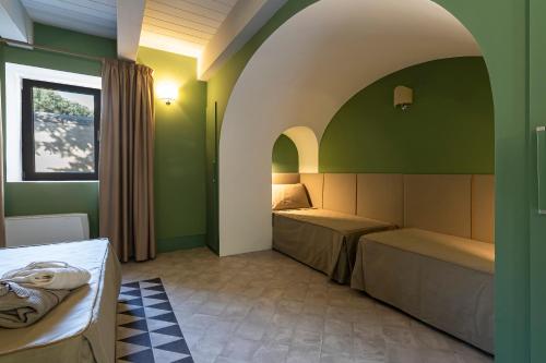 a bedroom with two beds in a room with an arch at San Filadelfo 
