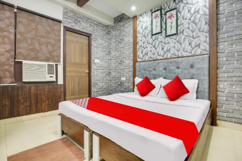a bedroom with a large bed with red pillows at Hotel O Inder Inn in Jalandhar