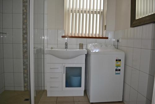 a bathroom with a sink and a washing machine at Longbeach Apartments in Coffin Bay