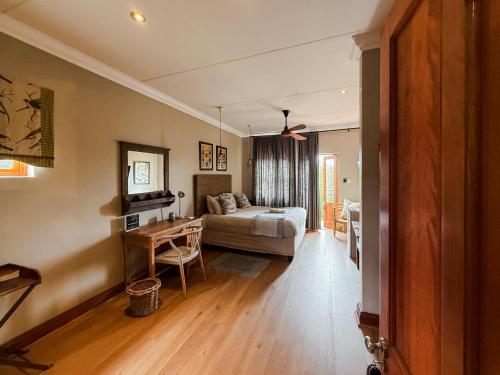 a living room with a bed and a table at The Urn Guesthouse in Middelburg