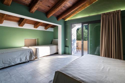 a bedroom with two beds and green walls and a patio at San Filadelfo 