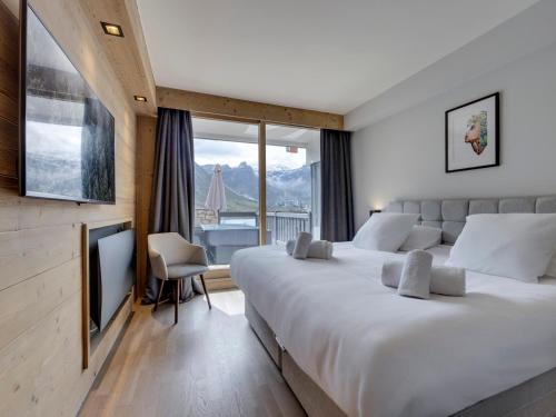 a bedroom with a large bed and a large window at Appartement au centre de Tignes avec terrasse et Wifi - FR-1-641-82 in Tignes