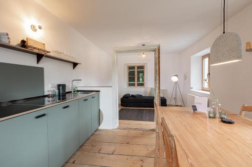 a kitchen with a counter top and a living room at GERN Magnolie in Unterwössen