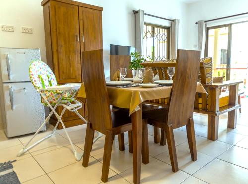 a dining room with a wooden table and chairs at Kounous Self-Catering Apartments in La Réunion