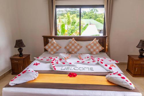 a bedroom with a bed with red flowers on it at Kounous Self-Catering Apartments in La Réunion