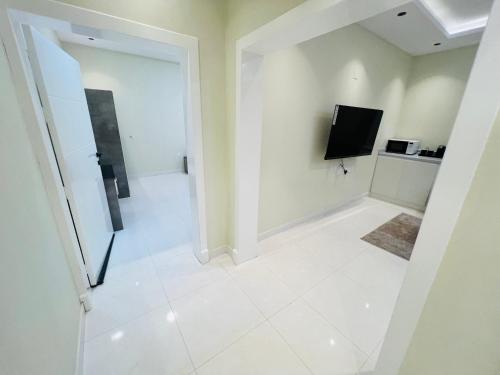 a white room with a television and a tiled floor at Village Sunset ڤيلـج سانـست in Al Namas