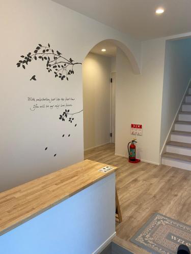 a living room with a staircase and a wall with a dandelion wall at アオイカゼ in Awaji