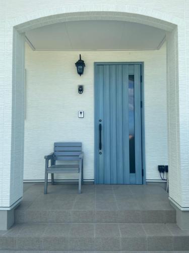 a bench sitting in front of a door at アオイカゼ in Awaji
