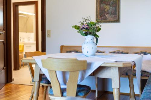 a table with a vase of flowers on top of it at Gasthof Waldschenke in Bad Leonfelden