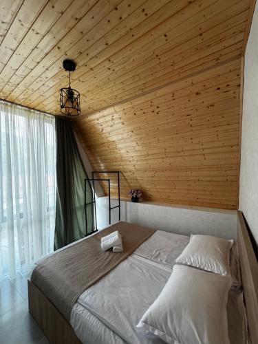 a bedroom with a bed with a wooden ceiling at Cottage Velli in Saketsia