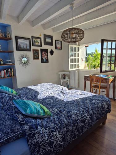 a bedroom with a bed with a blue comforter at B&B La Fleur in Saint-Fargeol