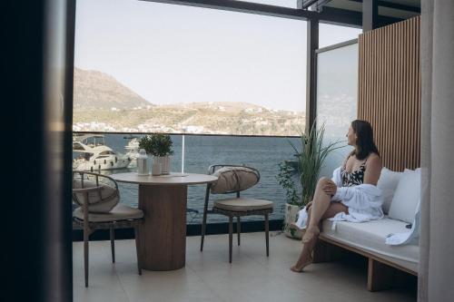 a woman sitting on a couch in a room with a table at Rea Boutique Hotel in Himare