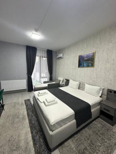 a bedroom with a large bed and a couch at Beshchinor Hotel in Yakkasaray