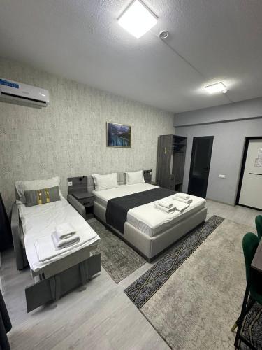 a hotel room with two beds and a couch at Beshchinor Hotel in Yakkasaray