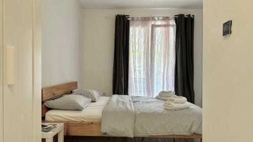 a bedroom with a bed and a window with towels at Apartments Lollipop in Novi Vinodolski