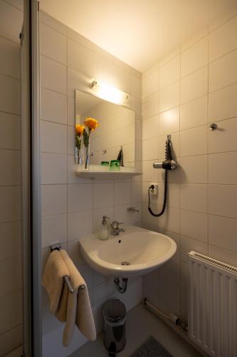 a white bathroom with a sink and a mirror at Gasthof Waldschenke in Bad Leonfelden