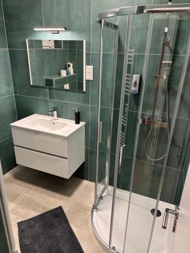 a bathroom with a glass shower and a sink at Nexus apartman in Siófok