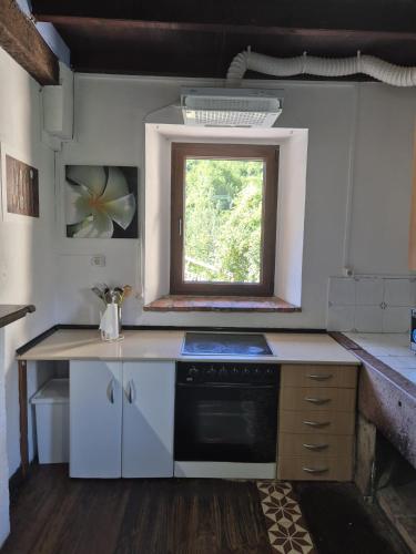 a kitchen with a stove and a window at Casa Rural Ribota! in Ribota