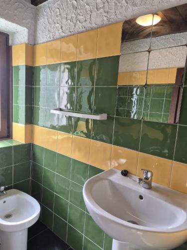 a green and yellow tiled bathroom with a sink at Casa Rural Ribota! in Ribota