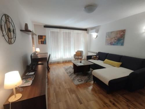 a living room with a couch and a table at Apartment RENA - private parking in Sarajevo