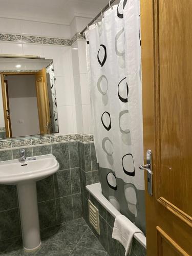 a bathroom with a sink and a shower curtain at Ukino Terrace Algarve Concept in Armação de Pêra