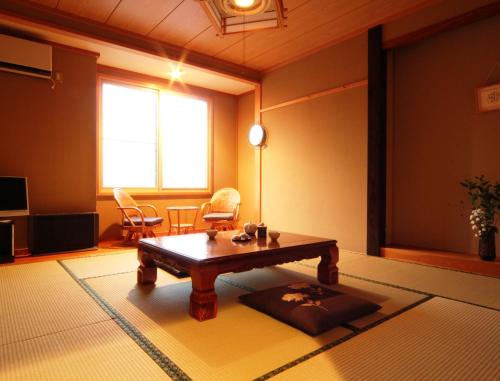 a living room with a coffee table in a room at Hatoguruma Kawabata in Nozawa Onsen
