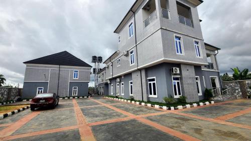 a building with a car parked in front of it at The Marble Hotel and Apartments in Uyo