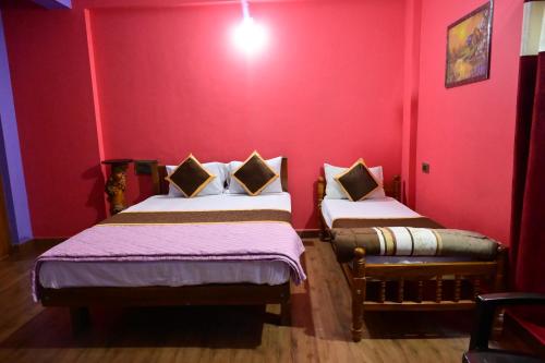 two beds in a room with red walls at DELIGHTFUL HOMESTAY in Sollebail