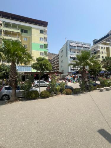a parking lot with palm trees in a city at RbNb Shengjin in Shëngjin