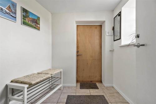 a hallway with a bench and a wooden door at FA004-Faxe-Ladeplads-Brandskov-4 in Fakse Ladeplads