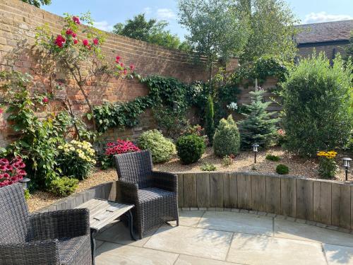 a garden with two chairs and a wooden bench at The Lodge in Birchington