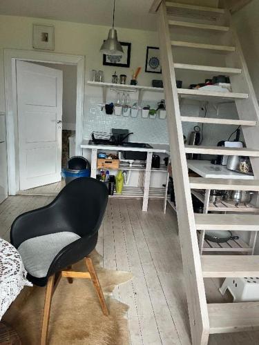 a black chair in a room with shelves at Apartmán pod lesem in Hazlov