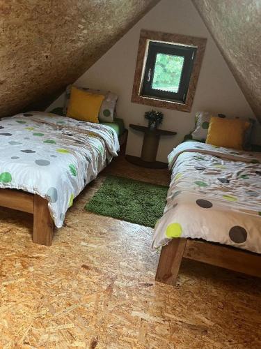 a bedroom with two beds and a window at Apartmán pod lesem in Hazlov