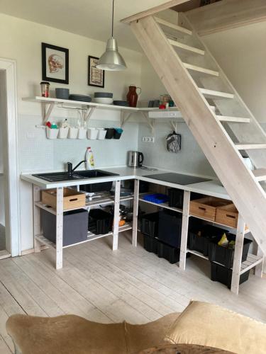 a kitchen with a sink and a staircase with shelves at Apartmán pod lesem in Hazlov