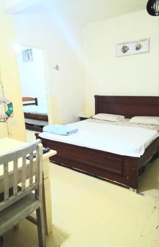 a bedroom with a bed and a bench at Residencial Praia Bertioga Pé na Areia in Bertioga