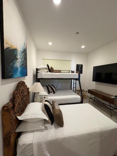 a room with three beds and a flat screen tv at Family-Friendly Oceanview Retreat Resort Access in Cabo San Lucas