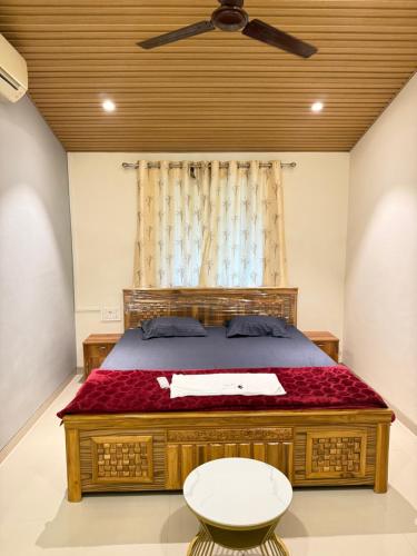 a bedroom with a bed with a ceiling fan at Villa 84 in Lonavala