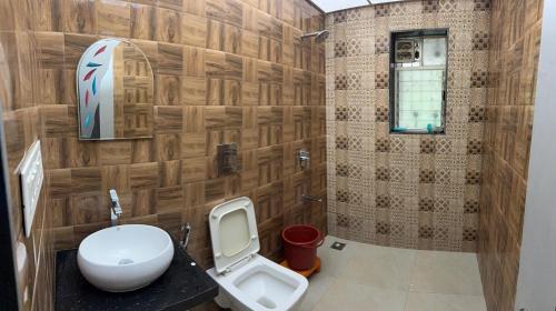 a bathroom with a toilet and a sink at Villa 84 in Lonavala