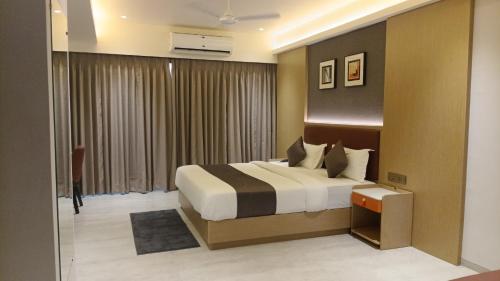 a hotel room with a bed and a window at Hotel Skyro Inn in Gandhinagar
