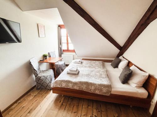 a bedroom with a bed and a desk and a window at Wellness hotel & minipivovar Kněžínek in České Budějovice