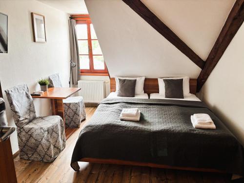 a bedroom with a bed and a table and a chair at Wellness hotel & minipivovar Kněžínek in České Budějovice