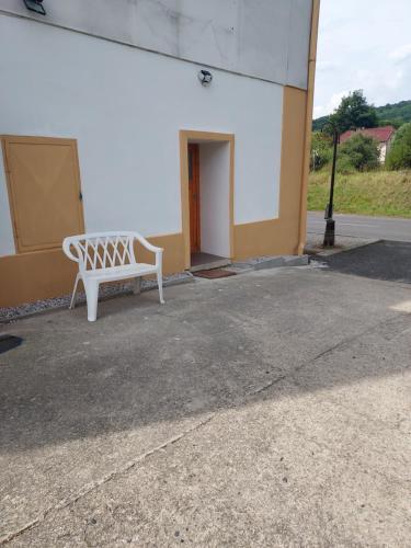a white bench sitting outside of a building at Apartmán v okresu Děčin 