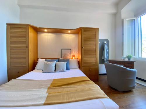 a bedroom with a large bed and a chair at La Spiaggia in Moneglia