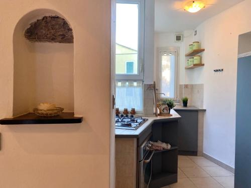 a kitchen with a stove top oven next to a window at La Spiaggia in Moneglia