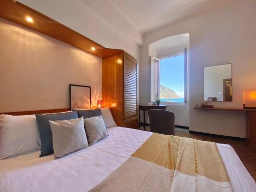 a bedroom with a bed and a desk and a window at La Spiaggia in Moneglia