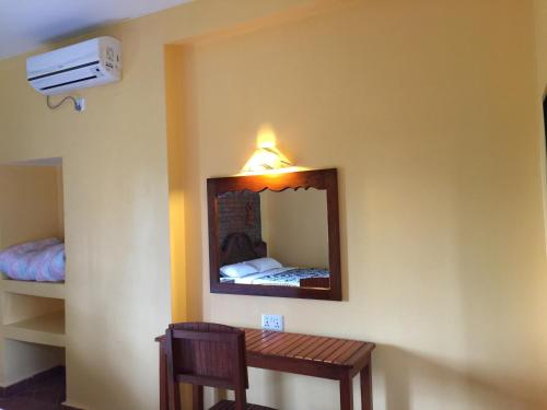 a mirror on the wall of a room with a table at Chautari Garden Resort in Sauraha