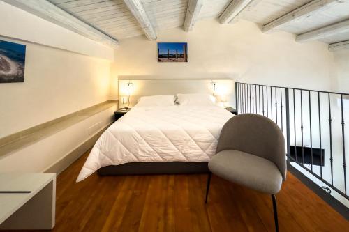 a bedroom with a white bed and a chair at Borgo Vita Novella Resort in Marzamemi