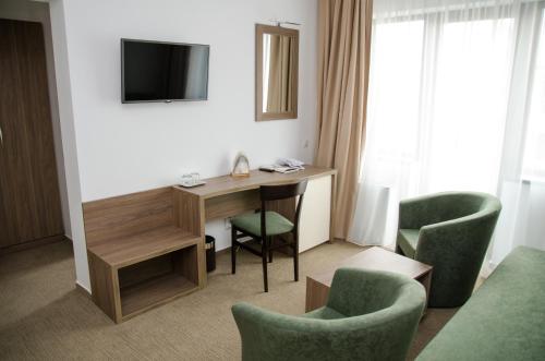 トゥルダにあるPotaissa Hotelのデスクと椅子2脚が備わるホテルルームです。
