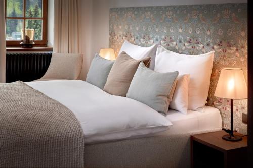 a bedroom with a white bed with pillows at Mount Med Resort in Oberau