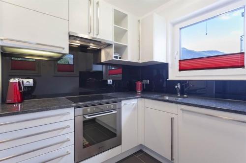 a kitchen with white cabinets and a window at Residence Salzgeber in Schruns-Tschagguns